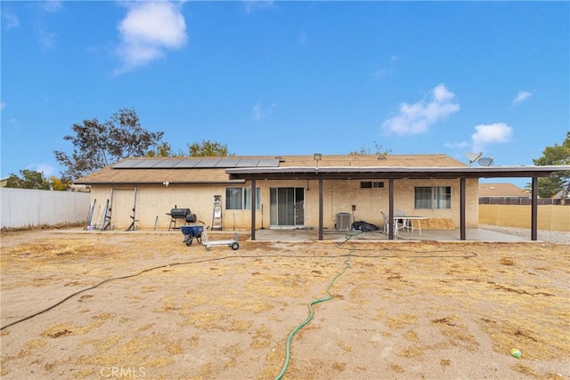 back of house featuring a patio area and solar panels