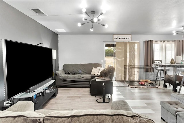 living room featuring light wood-type flooring and a notable chandelier