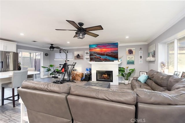 living room with ceiling fan, light hardwood / wood-style floors, and ornamental molding