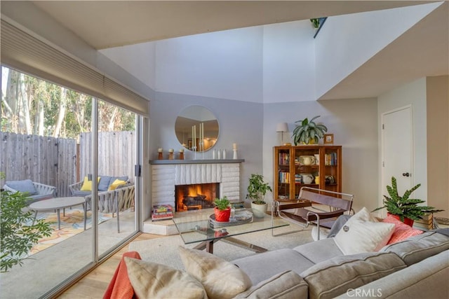 living room featuring light hardwood / wood-style flooring and a brick fireplace