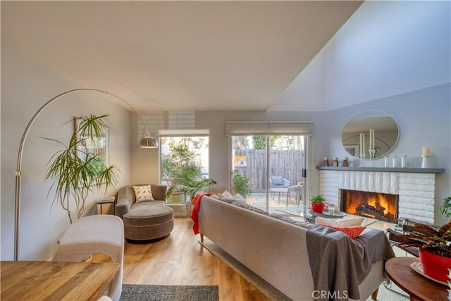 living room with hardwood / wood-style flooring and a brick fireplace