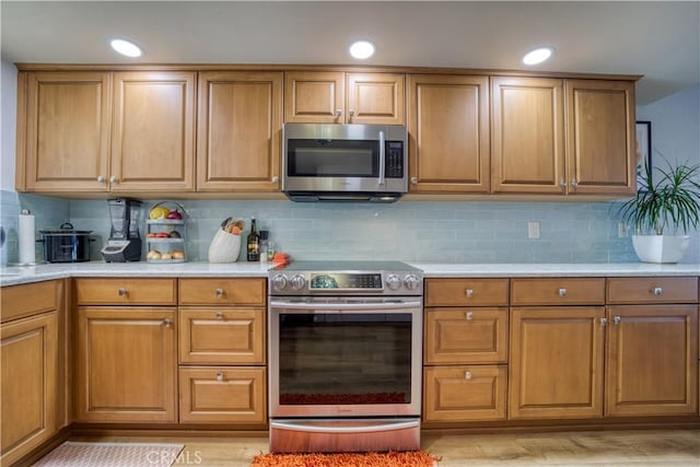 kitchen featuring light hardwood / wood-style floors, appliances with stainless steel finishes, and tasteful backsplash