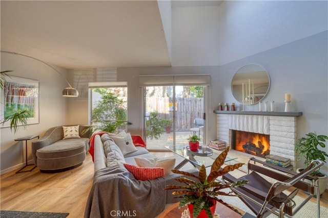 living room featuring wood-type flooring and a brick fireplace