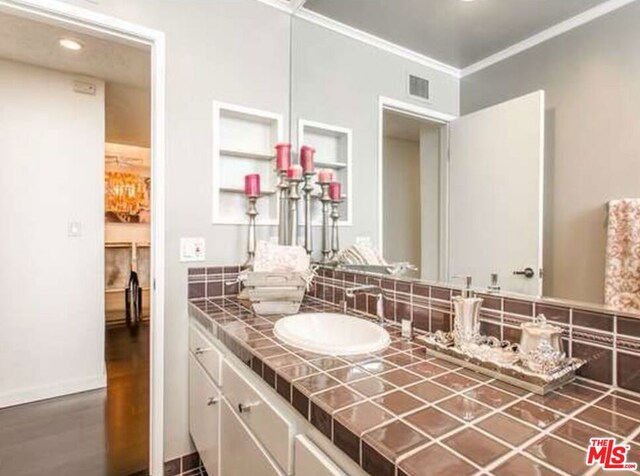 bathroom featuring crown molding, vanity, and hardwood / wood-style flooring