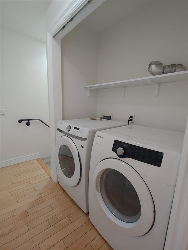 washroom featuring washer and dryer and light hardwood / wood-style floors