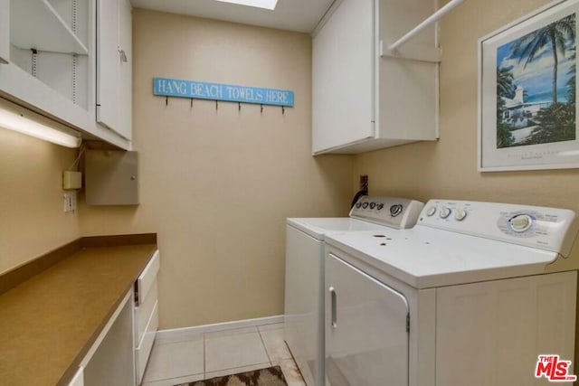 clothes washing area featuring cabinets, independent washer and dryer, and light tile patterned floors