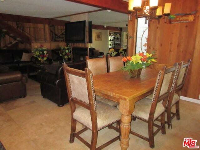 dining room with wood walls and a chandelier