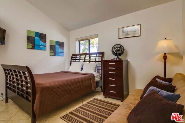 tiled bedroom featuring vaulted ceiling