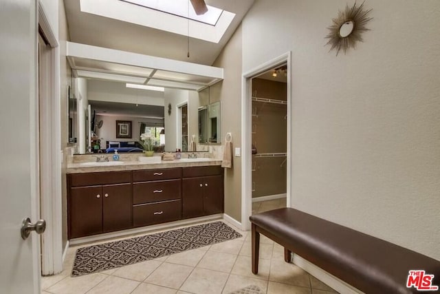 bathroom featuring tile patterned floors, a skylight, ceiling fan, and vanity