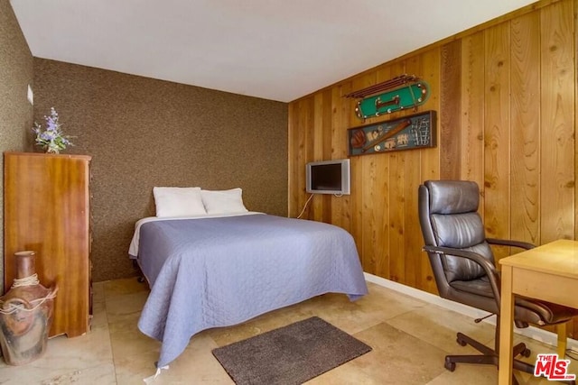 bedroom featuring wood walls