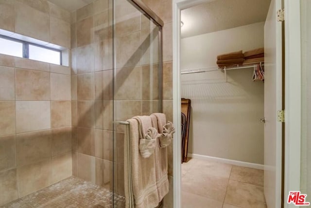 bathroom with tile patterned floors and a shower with door