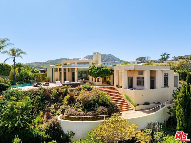 rear view of house with a mountain view and a patio