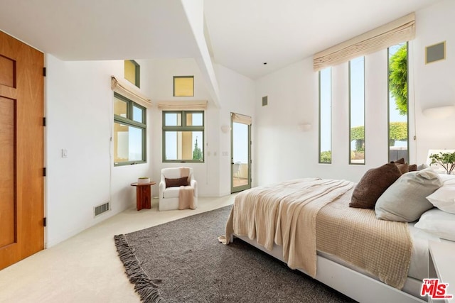 carpeted bedroom featuring high vaulted ceiling