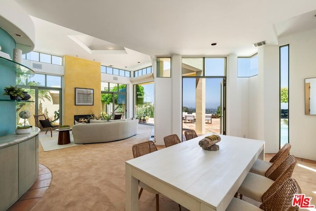 carpeted dining space featuring floor to ceiling windows and a fireplace