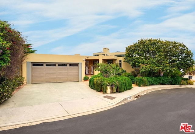 pueblo revival-style home with a garage