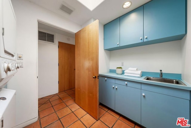 kitchen featuring blue cabinetry, light tile patterned flooring, and sink