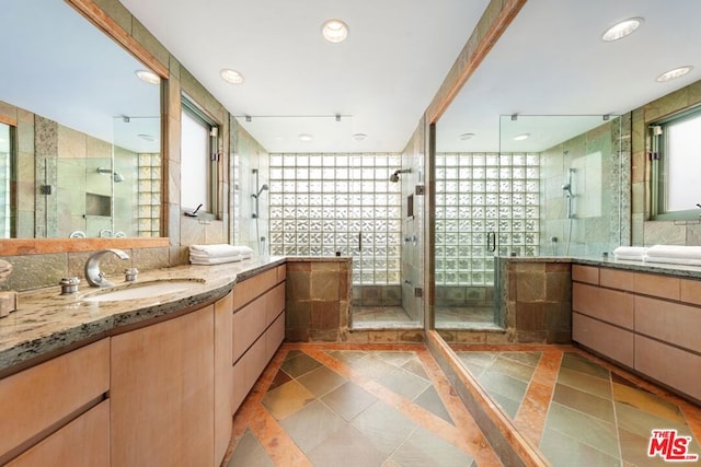 bathroom featuring tile patterned floors, vanity, a healthy amount of sunlight, and a shower with shower door