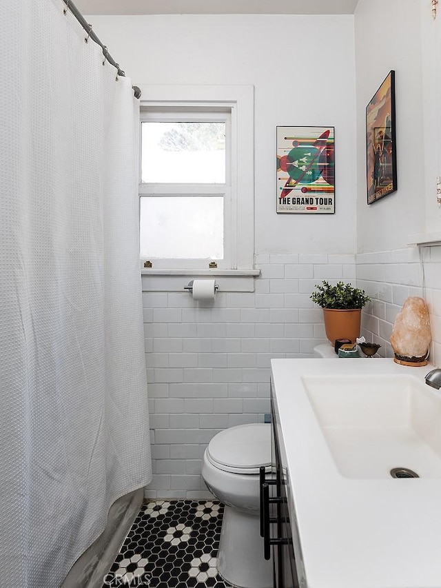 bathroom with tile patterned floors, a shower with curtain, tile walls, and toilet