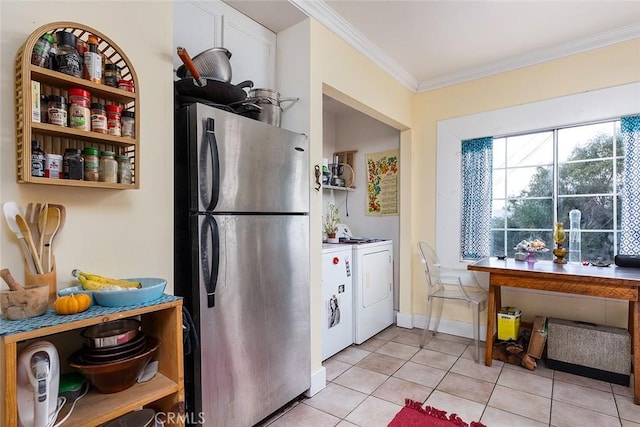 kitchen featuring washing machine and clothes dryer, stainless steel fridge, crown molding, and light tile patterned floors