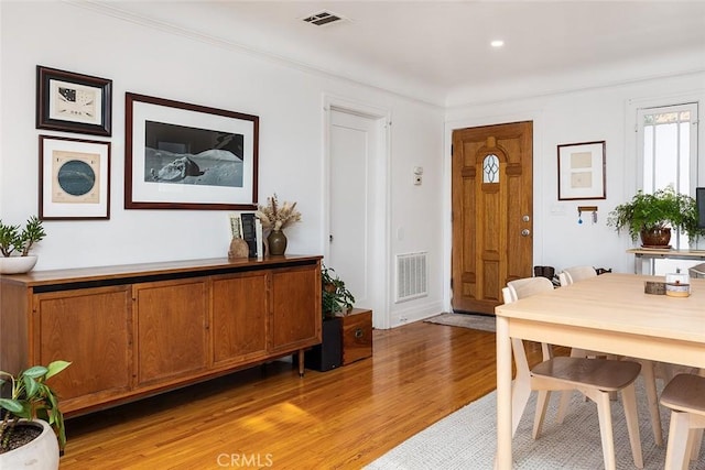 foyer with crown molding and light wood-type flooring