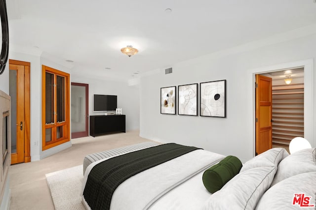 bedroom featuring crown molding, light carpet, and a fireplace