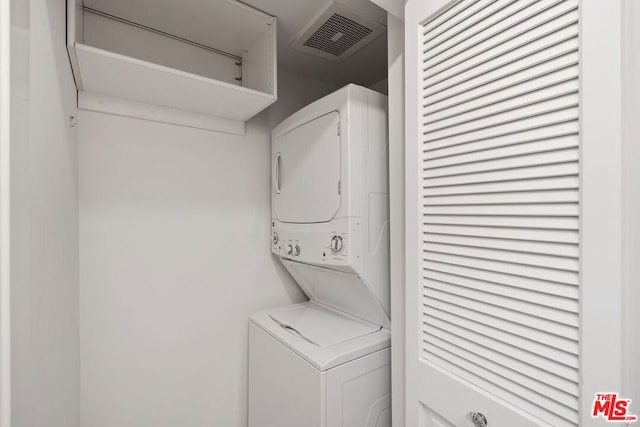 washroom featuring stacked washer / dryer