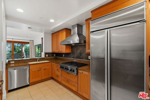 kitchen featuring wall chimney range hood, sink, light tile patterned floors, backsplash, and stainless steel appliances