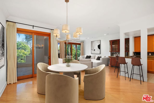 dining area featuring light hardwood / wood-style flooring and a notable chandelier