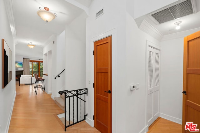 corridor featuring crown molding and light wood-type flooring