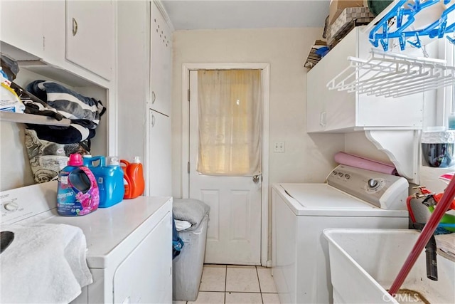 laundry area with light tile patterned flooring, cabinets, independent washer and dryer, and sink