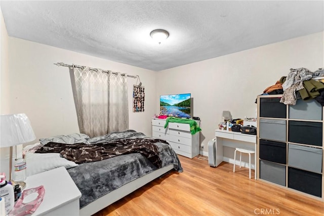 bedroom with wood-type flooring and a textured ceiling