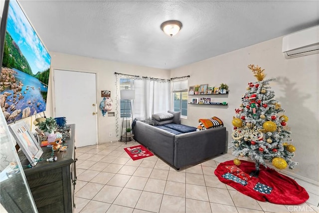 living room with a wall mounted AC, light tile patterned floors, and a textured ceiling