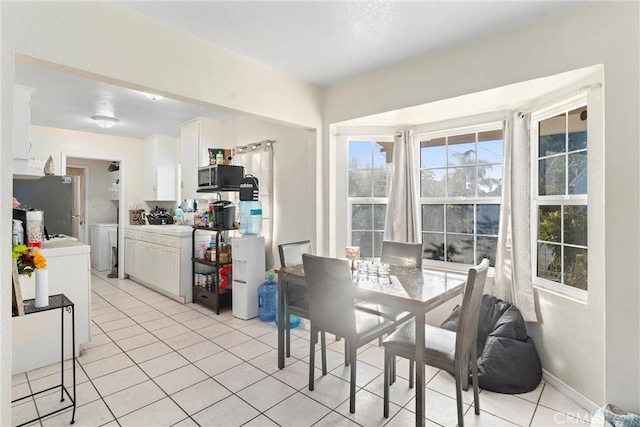 dining room featuring independent washer and dryer and light tile patterned floors