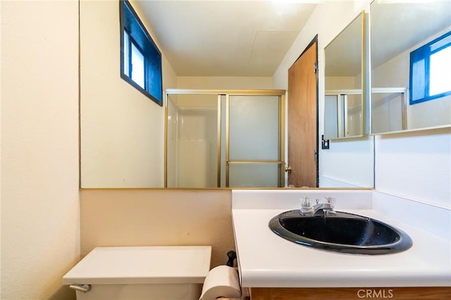 bathroom featuring walk in shower, vanity, and toilet