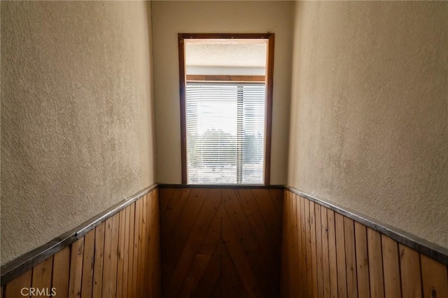 empty room featuring wooden walls and hardwood / wood-style floors