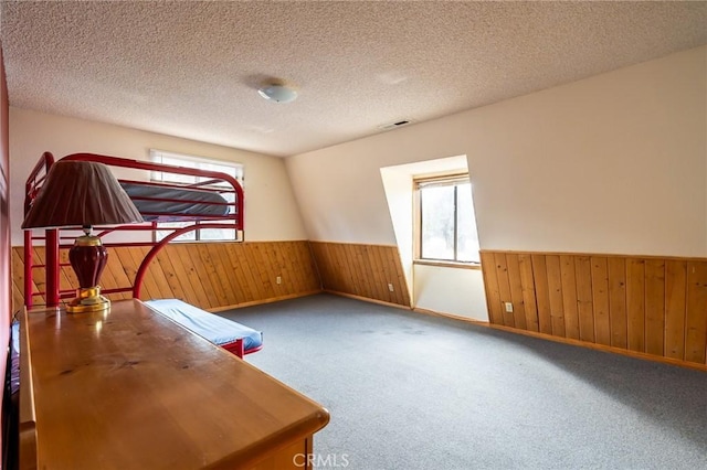 office with carpet, a textured ceiling, and wooden walls