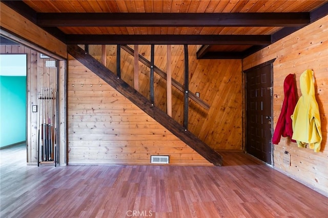 interior space featuring wooden walls, beamed ceiling, wood ceiling, and hardwood / wood-style flooring