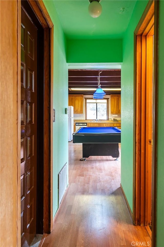 hallway with hardwood / wood-style floors and sink