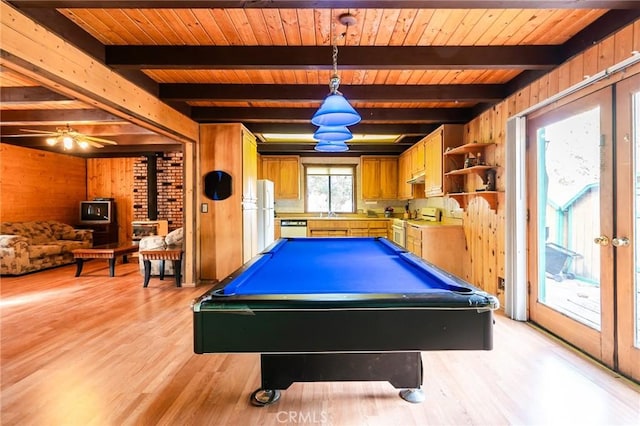 recreation room with beam ceiling, light wood-type flooring, a wood stove, and billiards