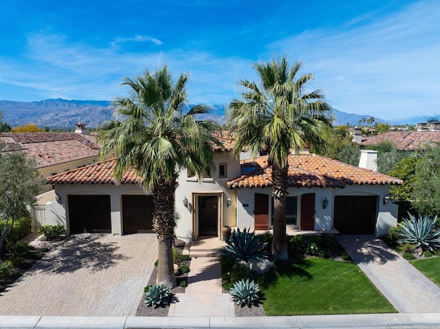 mediterranean / spanish-style home with a mountain view and a garage