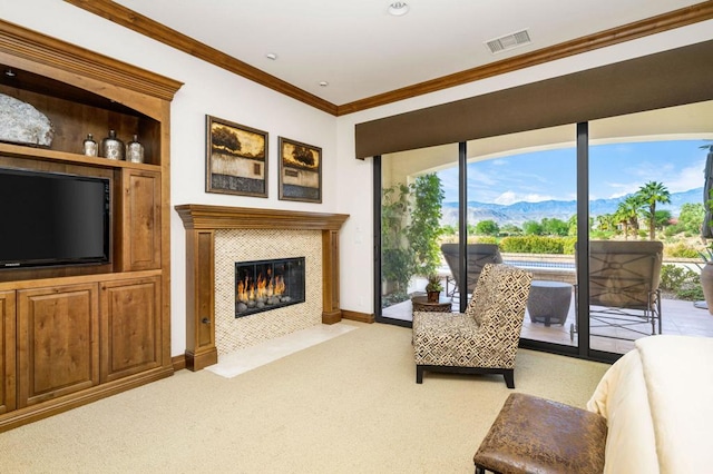 carpeted living room with a mountain view, crown molding, plenty of natural light, and a fireplace