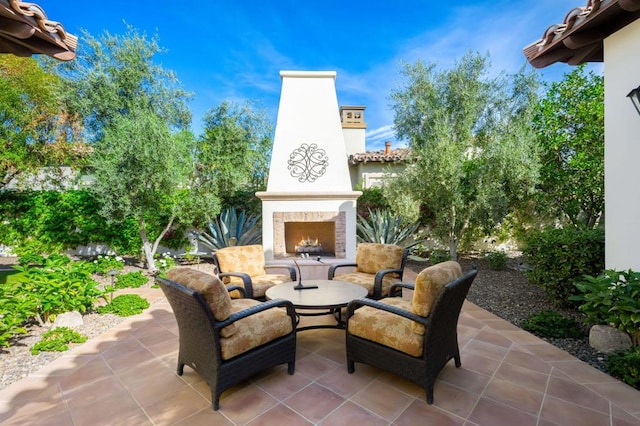 view of patio with exterior fireplace