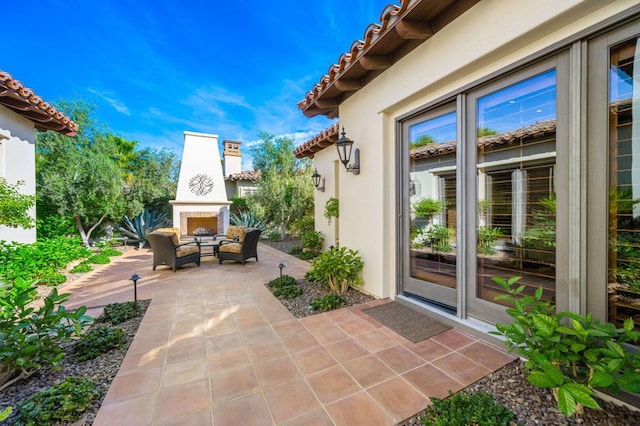 view of patio with exterior fireplace