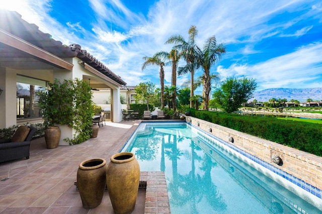 view of swimming pool featuring a mountain view and a patio