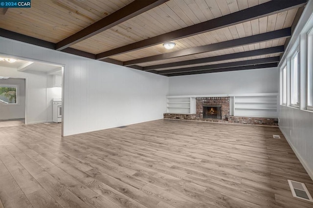 unfurnished living room featuring beamed ceiling, light hardwood / wood-style floors, wood ceiling, and a brick fireplace