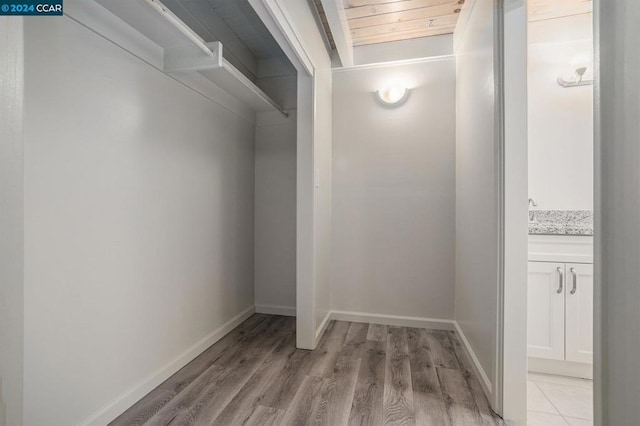 walk in closet with light hardwood / wood-style flooring