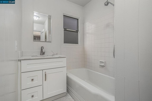 bathroom with tile patterned floors, vanity, and tiled shower / bath combo