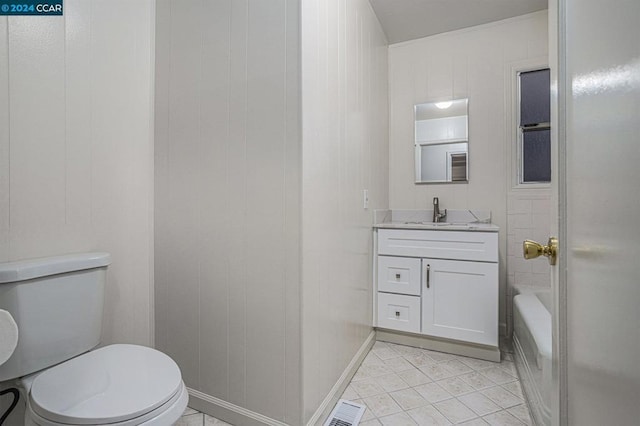 bathroom featuring tile patterned flooring, vanity, wood walls, and toilet