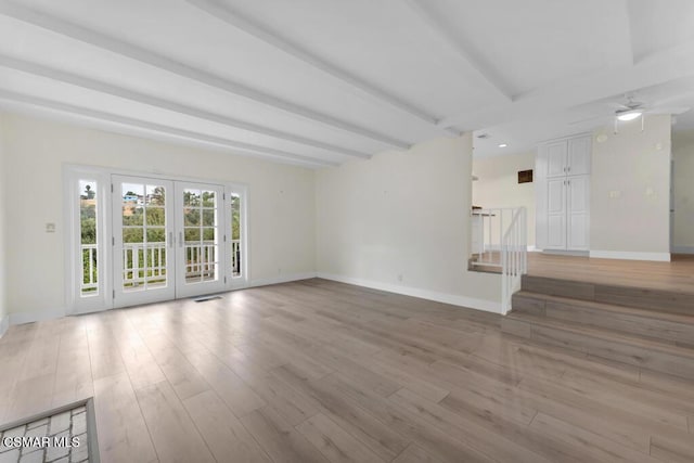 unfurnished living room with french doors, ceiling fan, beam ceiling, and light wood-type flooring