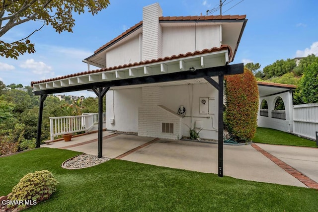 rear view of property featuring a carport and a yard